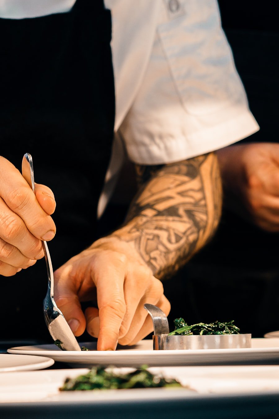 Chef finishing a plate with tweezers in the kitchen