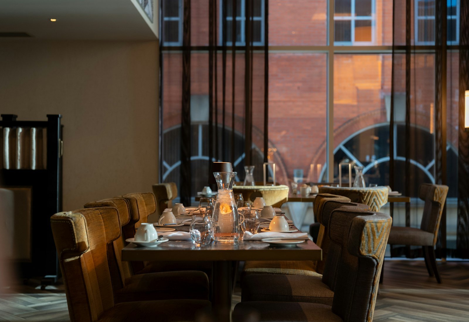 The chef's table set for service beside tall castle windows